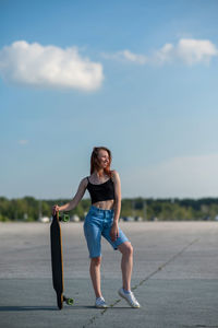 Full length of woman standing on road against sky