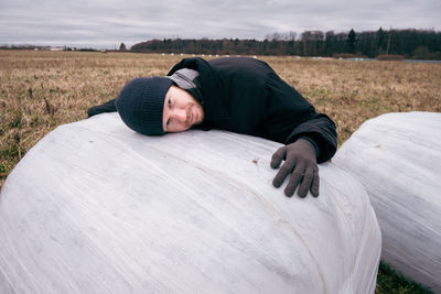 Portrait of man lying on haystack