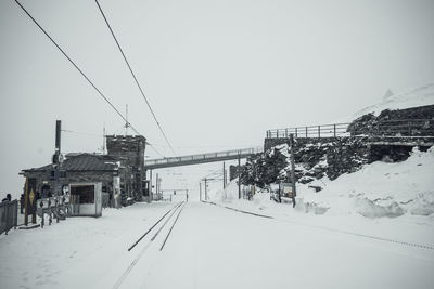 Snow covered buildings against clear sky