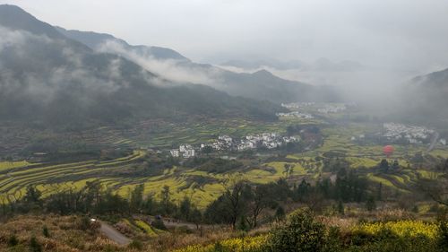 Aerial view of landscape against sky during foggy weather