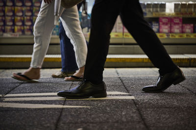 Low section of man walking on road