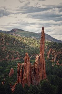 View of rocks on mountain against cloudy sky