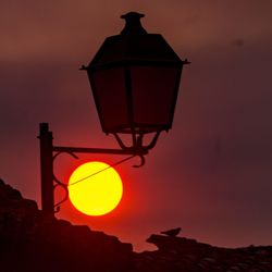 Low angle view of street light against orange sky