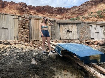 Full length of woman standing on building against mountain