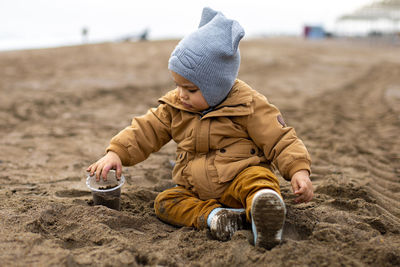 Cute little baby boy playing in a sand on the beach