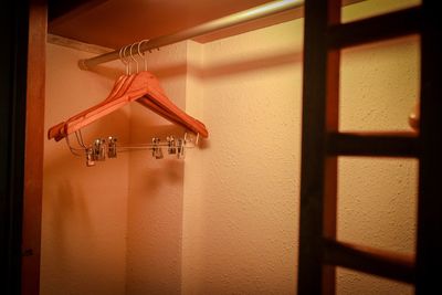 Close-up of electric lamp hanging on wall at home