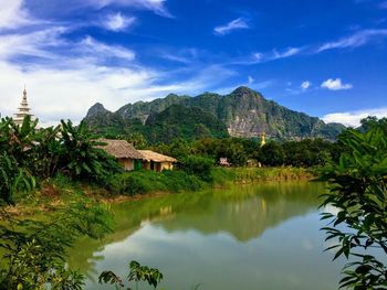 Scenic view of lake by buildings against sky