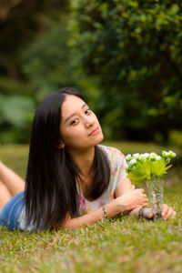 Portrait of young woman lying in grass