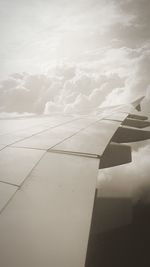 Aerial view of airplane wing over clouds