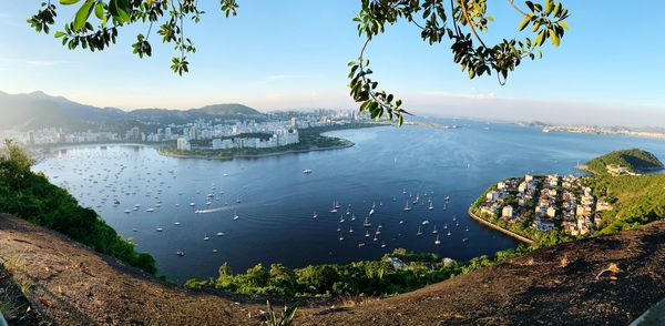 High angle view of cityscape by sea against sky