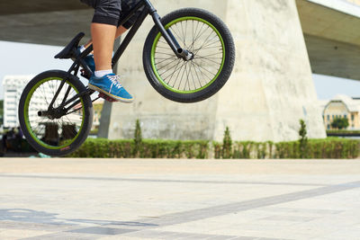 Low section of man riding bicycle on street