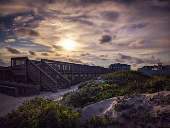 Sand dunes by an old pier in the sunset.