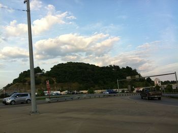 Cars on road by city against sky