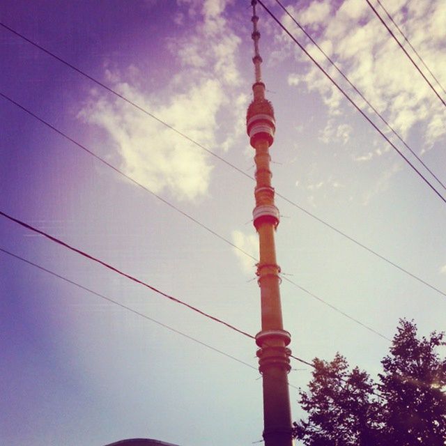 low angle view, power line, sky, cable, connection, electricity pylon, cloud - sky, power supply, electricity, architecture, built structure, cloud, cloudy, blue, tall - high, technology, tower, no people, outdoors, building exterior