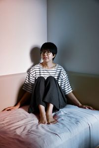Boy sitting on bed at home