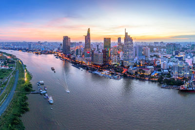 Aerial view of city at waterfront during sunset