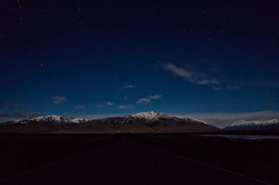 Scenic view of snowcapped mountains against sky at night
