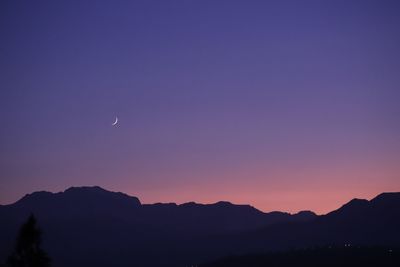 Scenic view of silhouette mountains against sky at night