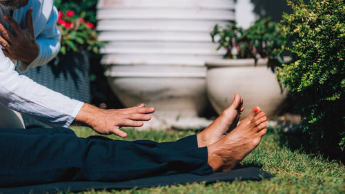 Hands of a reiki therapist healing and balancing energy points in feet. energy healing concept