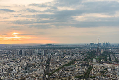 Aerial view of cityscape against cloudy sky