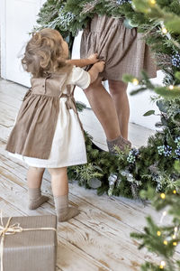 A young woman with blonde hair and a little daughter with a christmas wreath. new year's concept