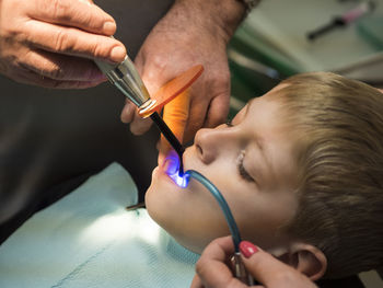 Close-up of dentist examining teeth of boy at clinic