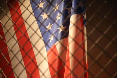 Close-up of american flag seen through metal grate