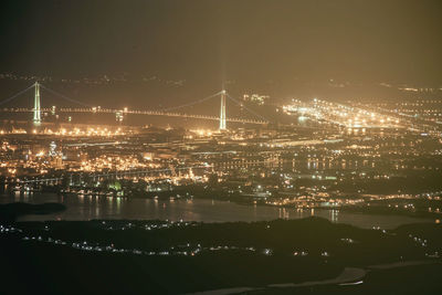 High angle view of illuminated city by river at night