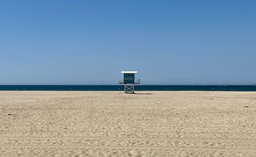 Lifeguard hut on beach against sky