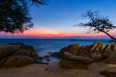 Motion seascape through stone arch at dawn with twilight sky in ko man klang, rayong, thailand. 