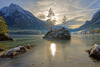 Scenic view of lake by snowcapped mountains against sky