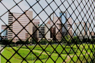 Close-up of chainlink fence against against city sky line