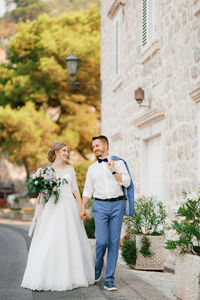 Rear view of couple holding umbrella