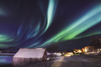 Scenic view of illuminated road against sky at night during winter