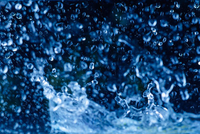 Close-up of water drops on glass against black background