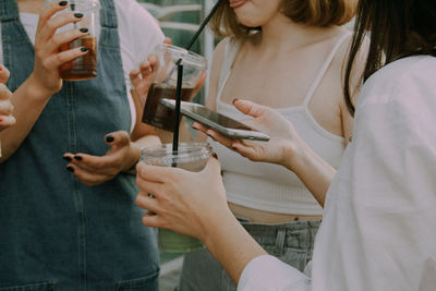 Midsection of woman holding smart phone