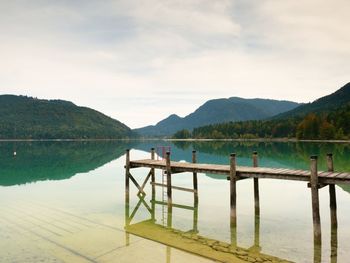 Empty wooden mole on blue alps lake, wharf for hired boats in marina. ready for trip ships.