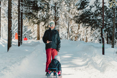 Full length of woman walking on snow covered field