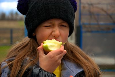 Girl eats a sour apple