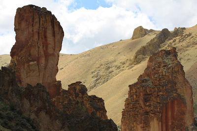 View of rock formations against cloudy sky