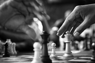 Close-up of men playing on chess board