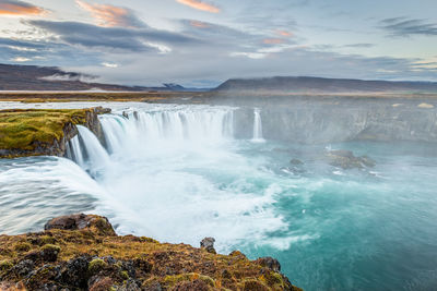 Scenic view of waterfall against sky