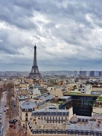 Aerial view of buildings in city against cloudy sky