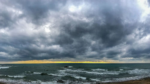 Scenic view of sea against storm clouds