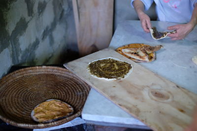 Midsection of chef holding bread at table in kitchen