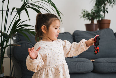 Carefree girl playing with toy at home