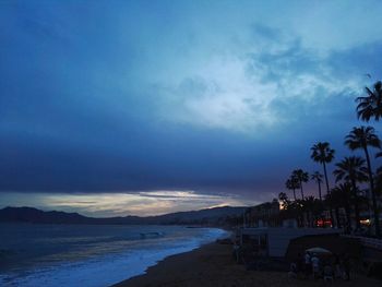Scenic view of beach against sky at sunset
