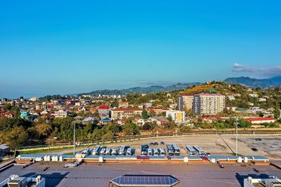 High angle view of buildings in city against blue sky