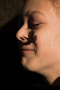 Close-up of butterfly perching on smiling girl