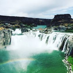 Scenic view of waterfall against sky